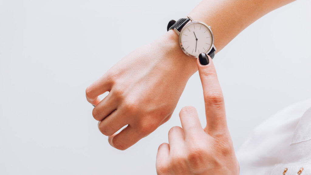 Professional presence - shows a lady's hand wearing a wristwatch, and the other hand pointing to the watch