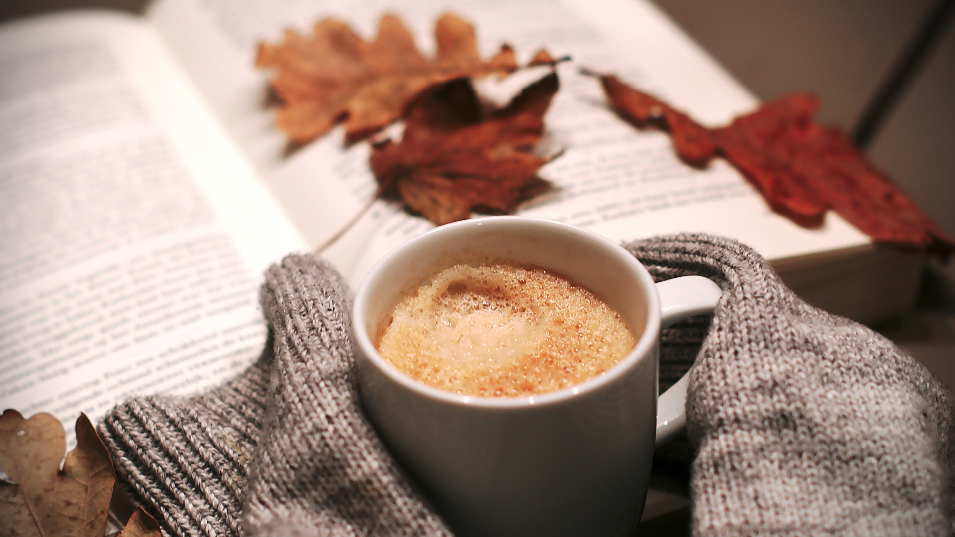 Coffee cup with a book and autumn leaves