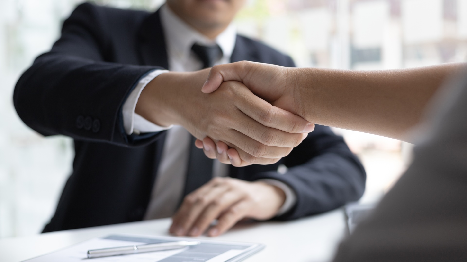 shaking hands with a man wearing a suit