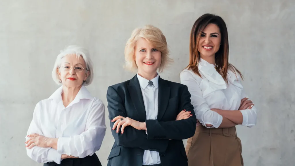 5 big life pillars image shows 3 professional woman standing confidently, wearing red lipstick