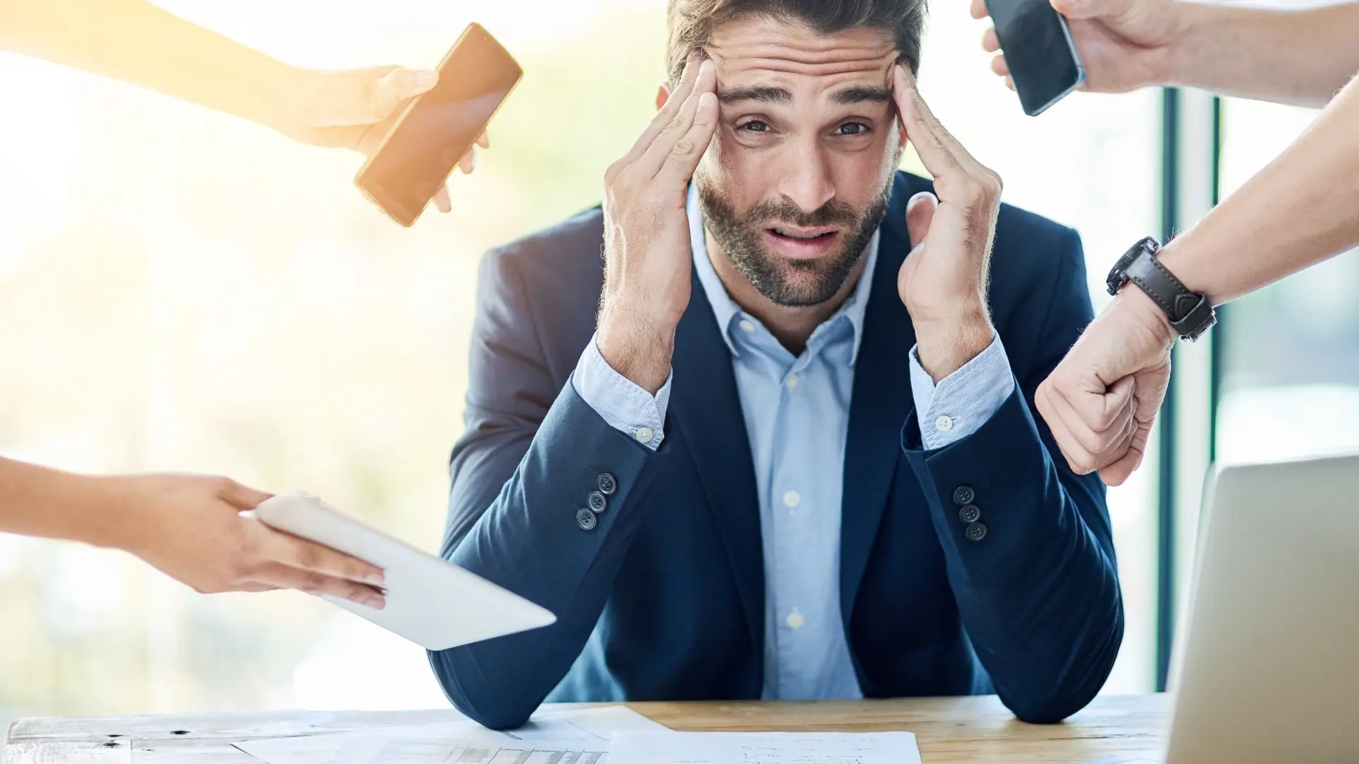 Stressed man overwhelmed by work demands