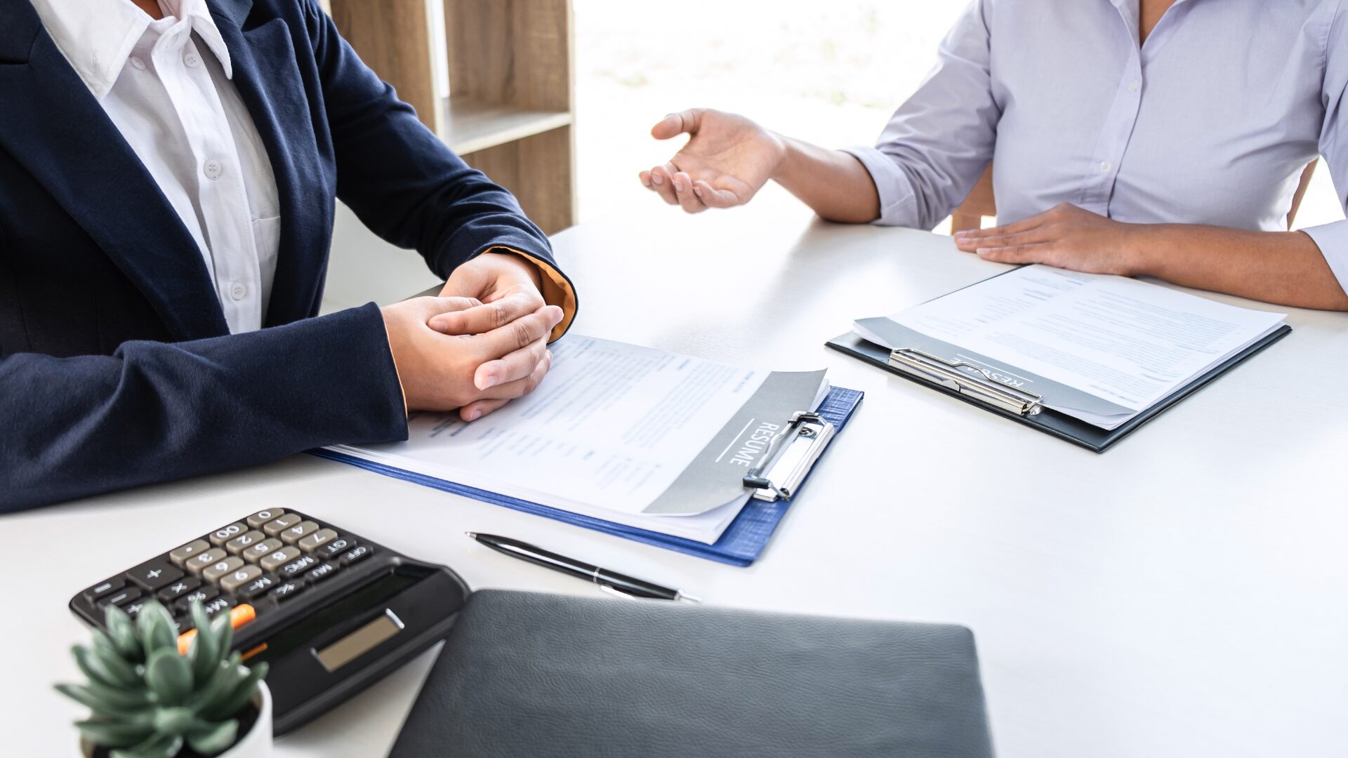 advocate for your career growth image shows the hands of two professionals with resumes in front of them on table