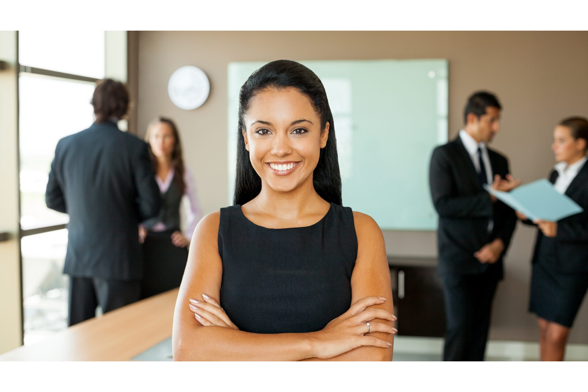 Information Flow Manager blog image shows a confident professional woman standing with arms crossed with two pairs of other professionals talking in the slightly blurry background